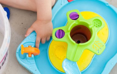 Çocuk eli renkli su oyunuyla oynuyor