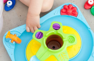 Çocuk eli renkli su oyunuyla oynuyor