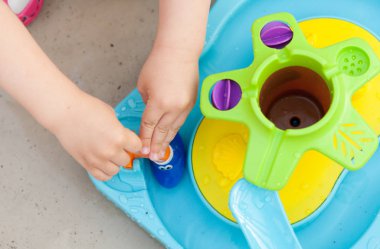 Çocuk eli renkli su oyunuyla oynuyor