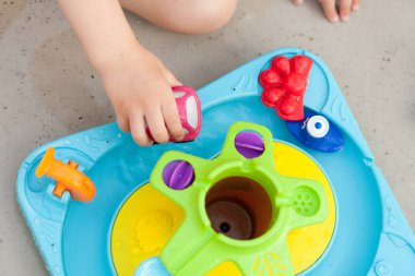 Çocuk eli renkli su oyunuyla oynuyor