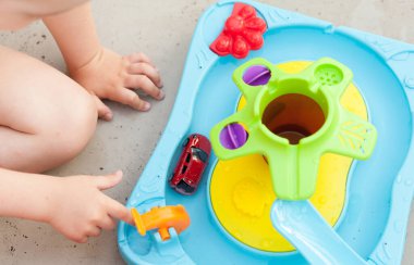 Çocuk eli renkli su oyunuyla oynuyor