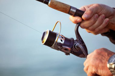 Kumsalda bir balıkçı sabahın erken saatlerinde balık yakalar.