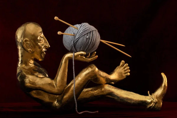 Estatuilla de oro con una bola de lana y agujas de punto — Foto de Stock