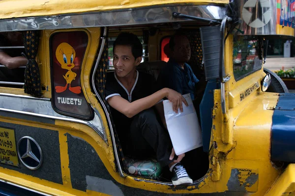 Manila, Filipinler - Ocak 25,2012: adam oturur jeepney haddeleme 