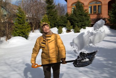 kadın bahçede bir kürek ile kar kaldırır
