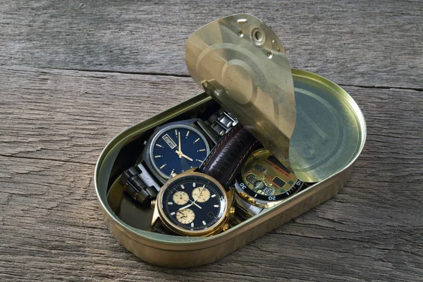 Tre orologi da polso in una scatola su un tavolo di legno — Foto Stock