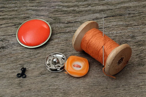 Κλωστές, κουμπιά, γάντζο και βελόνα σε ένα ξύλινο τραπέζι — Φωτογραφία Αρχείου