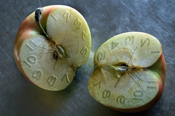 Duas metades de maçãs com uma cara de relógio — Fotografia de Stock