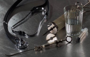 Şırıngalar, alkol ile bir bardak ve bir steteskop çeşitli