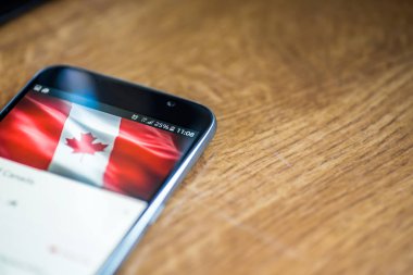 Ahşap arka plan 5g ağ işareti yüzde 25 ücret ve Kanada bayrağı üstünde belgili tanımlık perde ile Smartphone