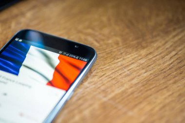 Ahşap arka plan 5g ağ işareti yüzde 25 ücret ve Fransa bayrağı üstünde belgili tanımlık perde ile Smartphone