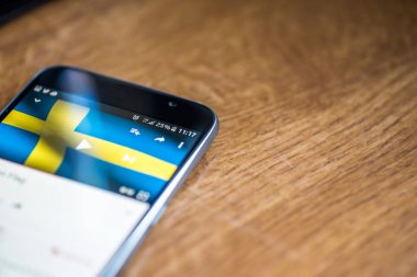 Ahşap arka plan 5g ağ işareti yüzde 25 ücret ve İsveç bayrağı üstünde belgili tanımlık perde ile Smartphone