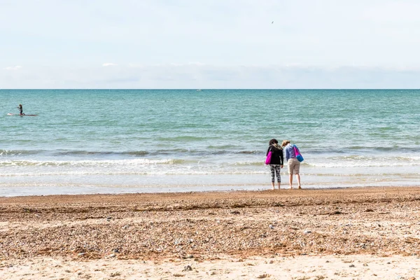 모래 해변에서 해 수를 시도 하는 두 여자 — 스톡 사진