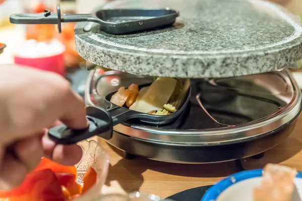 Вид на семейный стол для приготовления пищи на Raclette — стоковое фото