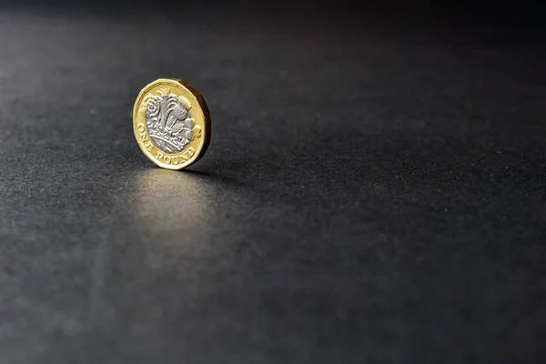 Nova moeda britânica de uma libra esterlina no fundo escuro — Fotografia de Stock