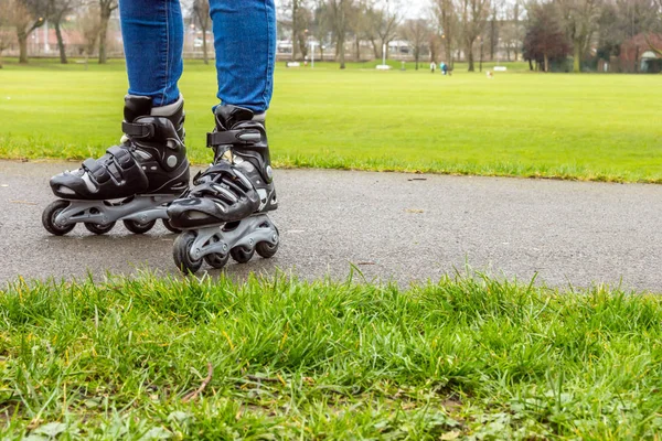 Zenske nohy na kolečkových bruslích v parku — Stock fotografie
