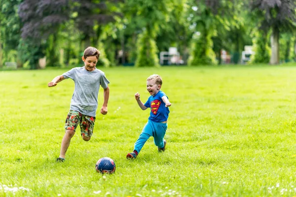 Widok dnia, dwóch chłopców gry piłkarskie lato park — Zdjęcie stockowe