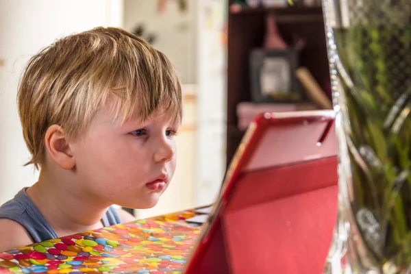 Jongetje kijken naar digitale tablet met gezicht expressie — Stockfoto