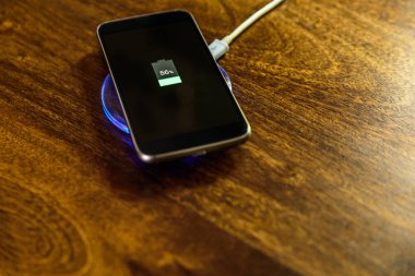 Şarj bir yastık üzerinde şarj Smartphone. Kablosuz şarj
