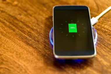 Şarj bir yastık üzerinde şarj Smartphone. Kablosuz şarj