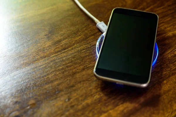 Smartphone charging on a charging pad. Wireless charging