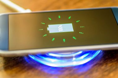 Şarj bir yastık üzerinde şarj Smartphone. Kablosuz şarj