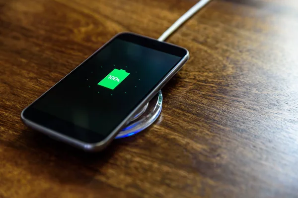 Smartphone charging on a charging pad. Wireless charging