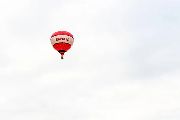 Rennbahn, northampton, england, uk - juli 01: Heißluftballon mit Dachpflege-Logo fliegt über northampton town festival — Stockfoto