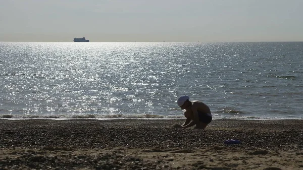 Genç çocuk İngiliz deniz, sahil kumu ile oynarken