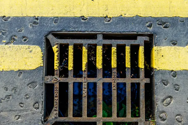 Detailní pohled na žluté vodorovné dopravní značení na Kanalizační mříže — Stock fotografie