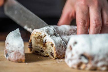 Closeup erkek el ahşap tahta üzerinde Mini Marzipan Stollen bıçak ile kesme