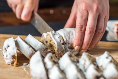 Closeup erkek el ahşap tahta üzerinde Mini Marzipan Stollen bıçak ile kesme