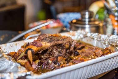 Biftek kavurma tepsisi meşgul mutfak masasında içinde kemik ile Kavrulmuş dana kaburga