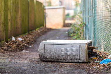 Kırık elektrik kutusu açık havada patika üzerinde maruz kablo teller ile düşmüş.