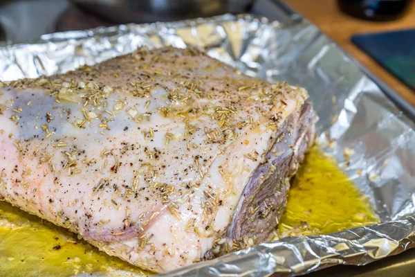 Nahaufnahme rohe Lammkeule auf Röstblechfolie mit zum Braten bereiten Zutaten — Stockfoto