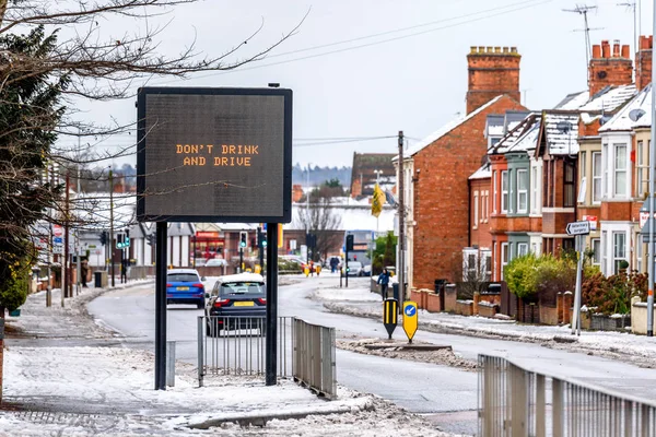 Хмарний день зими зору сучасних інформаційних ознак зі словами, не п'ю і їзди на типовий англійський дороги під снігом — стокове фото