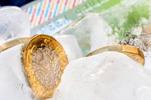 Frozen New British one pound sterling coin up close macro inside ice cubes — Stock Photo, Image