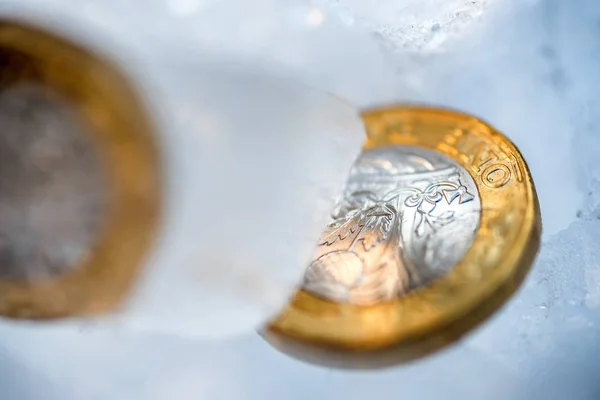 Frozen New British one pound sterling coin up close macro inside ice cubes