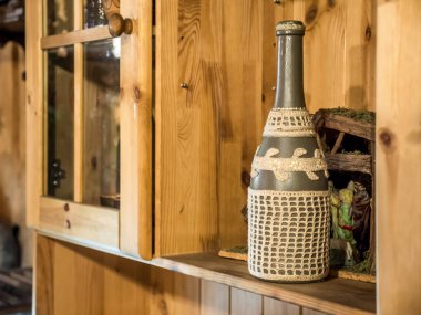Vintage seramik işlemeli şarap şişesi ahşap raf