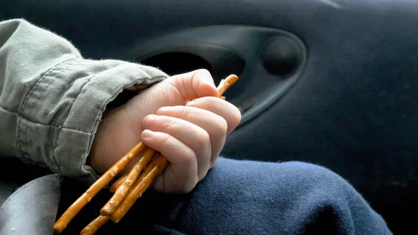 Close-up weergave kind hand houden en koekjes eten onderweg in de auto — Stockfoto