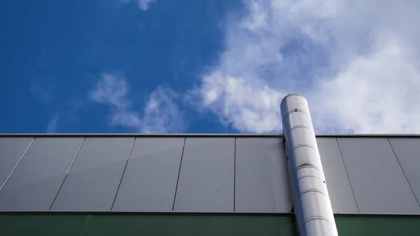 Låg vinkel syn på fabrik skorstenen med grå rök över ljusa solig himmel i England — Stockfoto