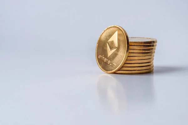 Gyllene virtuella pengar Ethereum krypto valuta mynt staplade på en mörk bakgrund — Stockfoto