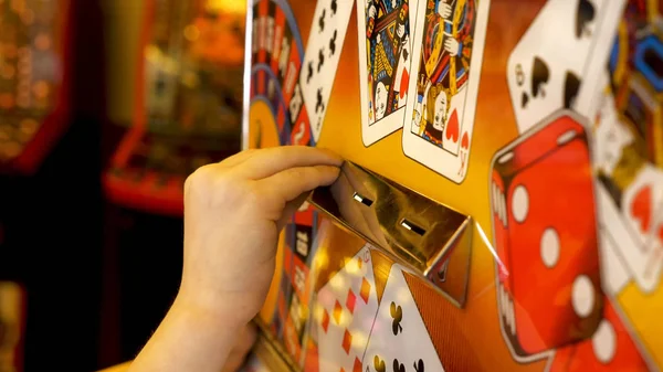 Närbild av Childs hands sätta mynt i Slots Machine — Stockfoto