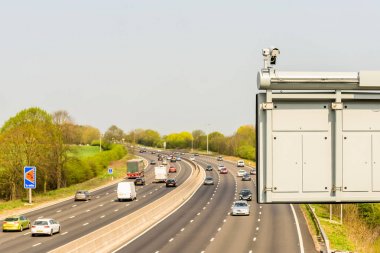 Ön plan üzerinde Cctv kamera ile İngiltere'de otoyol trafik güneşli gün görünümü