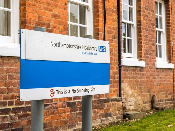 Daventry, Reino Unido 23 de março de 2018: Northamptonshire Healthcare NHS Foundation Trust Sign Post with warning This is No Smoking Site — Fotografia de Stock