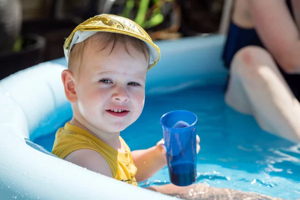 Uśmiechnięty maluch w basenie z plastikowym szkłem pod ostrym słońcem w Anglii uk — Zdjęcie stockowe