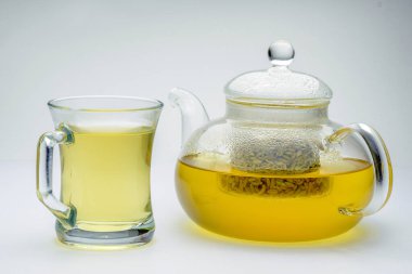 Cam çaydanlığın içine salınan rezene tohumları beyaz arka planda sağlıklı bir içecek için demlenmiştir.