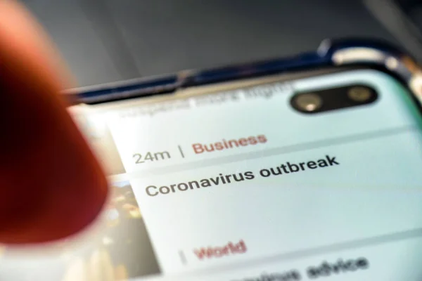 Coronavirus outbrake text on smart phone screen - Northampton, UK - February 25, 2020 — Stock Photo, Image