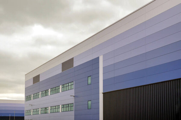 modern warehouse building over cloudy sky in england uk
