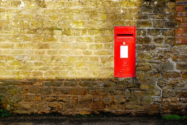 Inglés post box on stone wall in village in england uk —  Fotos de Stock